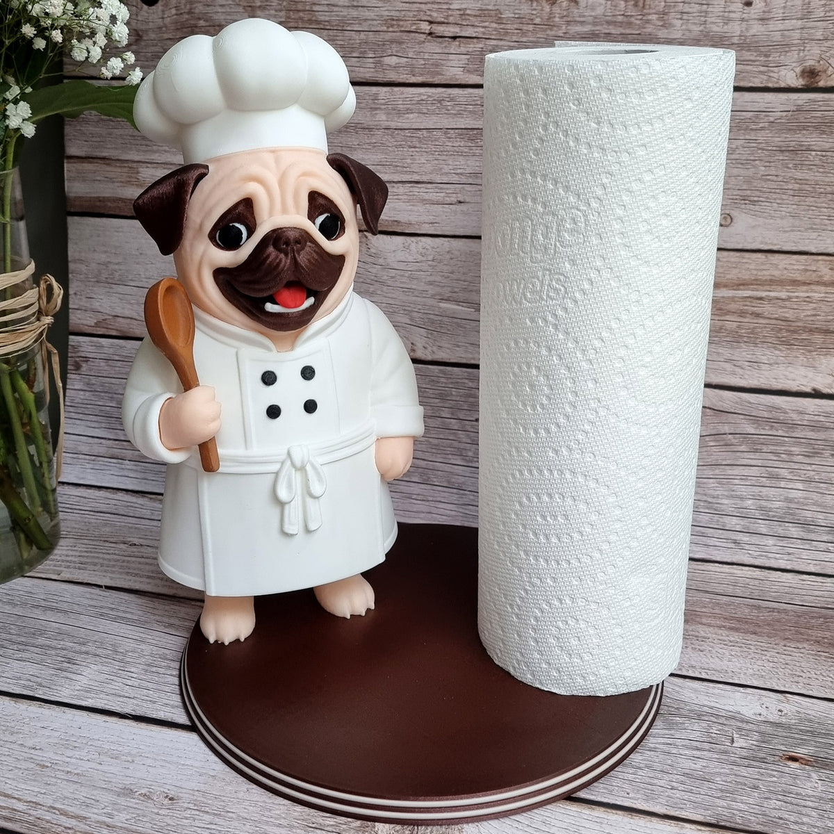 Front view of the pug chef with a roll loaded and the wooden spoon raised
