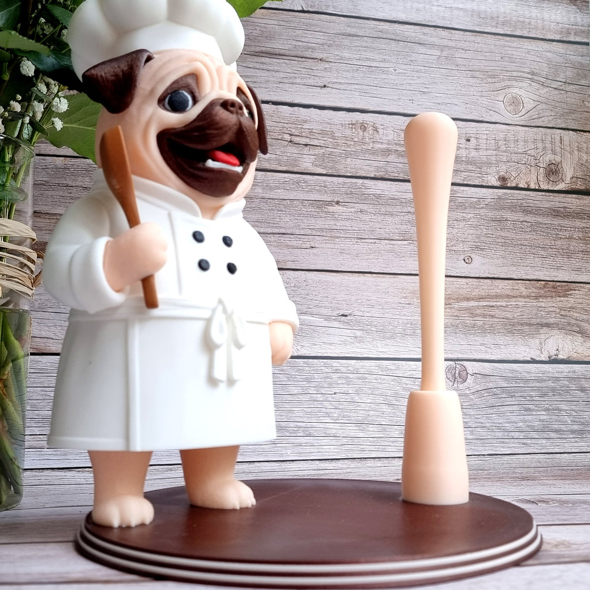 The holder with the rod empty, showing how tall a roll it takes, wooden spoon in the pug's paw