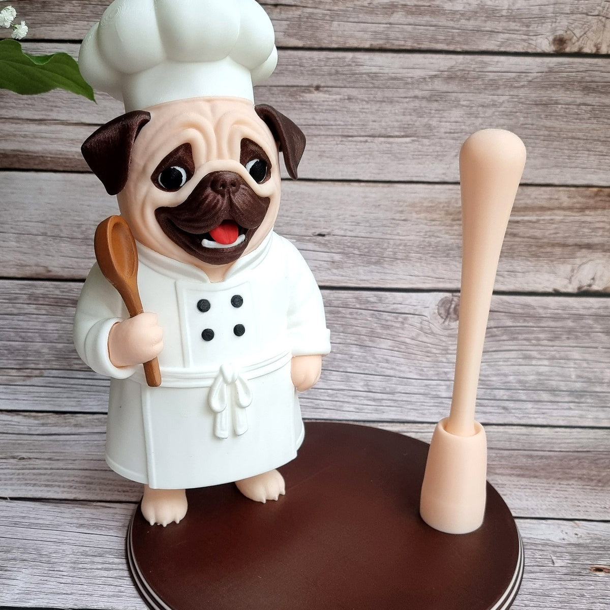 The pug chef on its round base with the rod empty, seen from the front